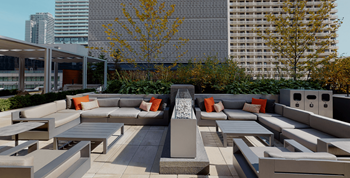 A modern outdoor seating area with a large concrete fountain in the center.